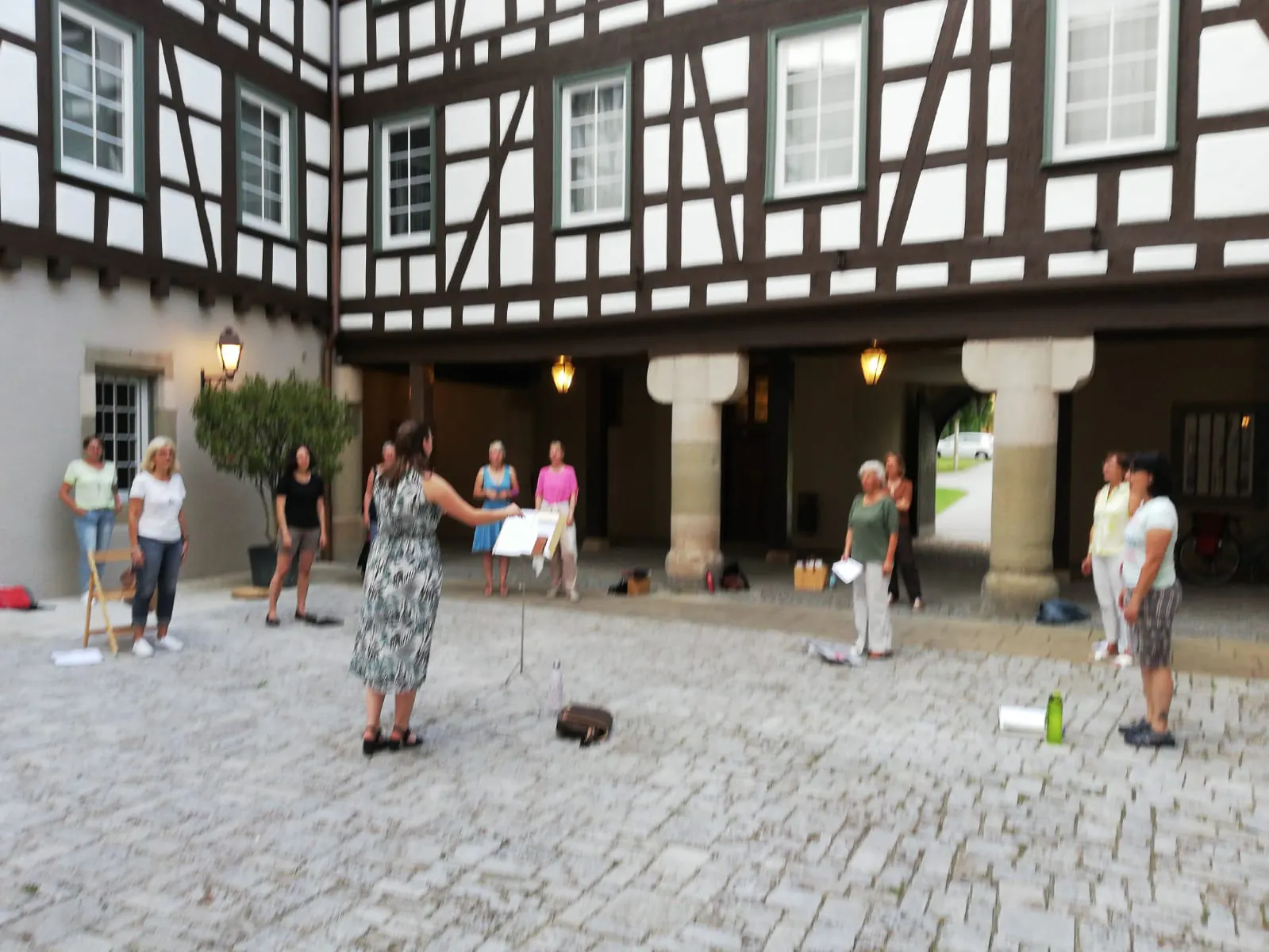 Der Frauenchor PopUp probt unter freiem Himmel im Innenhof eines Fachwerkhauses in Schorndorf.